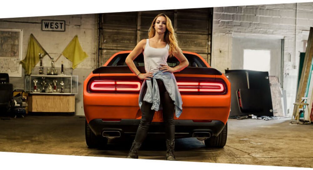 young girl model next to dodge challenger rear spoiler taillights